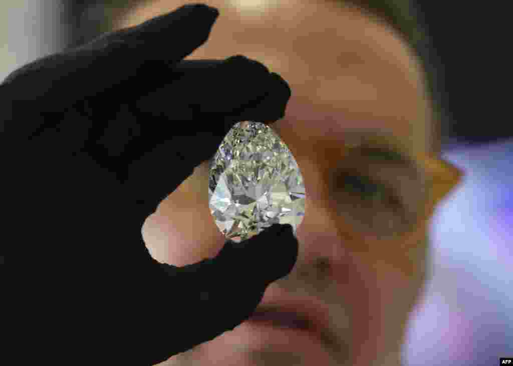 A Christie&#39;s auction house staff member displays for the media a giant diamond nicknamed &quot;The Rock,&quot; in Dubai, ahead of an auction where it is expected to fetch up to $30 million.
