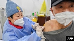 中国山东省青州的医护人员在给一名男子接种新冠疫苗。（2022年12月29日）
