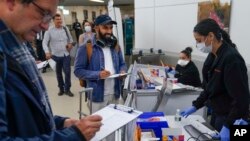 航班乘客舒布哈姆·钱德拉(Shubham Chandra)2023年1月4日在纽瓦克机场接受匿名COVID-19检测。