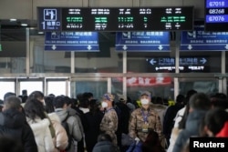 中国武警士兵在上海火车站里指挥春运人潮排队等候。（2023年1月16日）