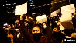 北京民众走上街头举起白纸游行抗议当局严厉的防疫封控措施。（2022年11月27日）