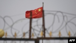 资料照片：新疆喀什南部地区一个院落挂出的中国国旗（2019年6月4日）