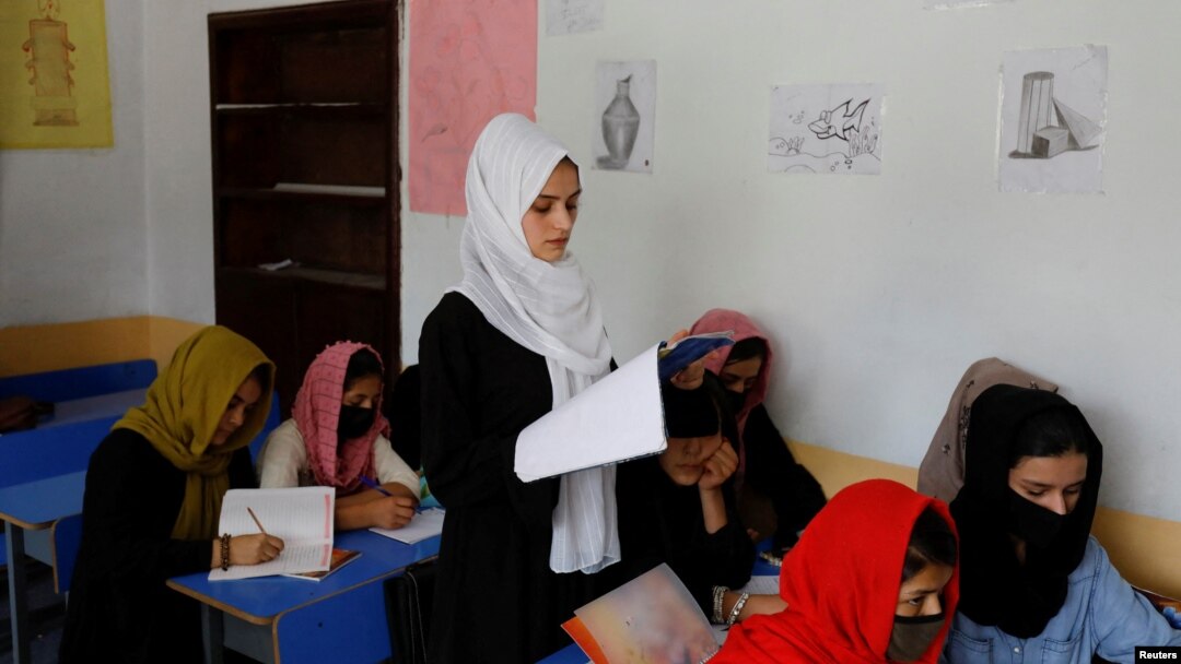FILE - Kerishma Rasheedi, 16, reads during a class at a private school class in Kabul, Afghanistan, Aug. 3, 2022. 