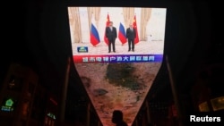 在乌兹别克斯坦举行的上海合作组织峰会期间，在中国北京的一块巨大显示屏正在播放中国国家主席习近平和俄罗斯总统普京的合影留念。(2022年9月16日)