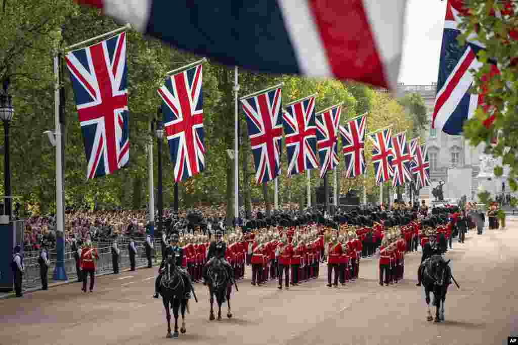 The military procession as the coffin of Queen Elizabeth II, draped in the Royal Standard, is carried on a horse-drawn gun carriage of the King's Troop Royal Horse Artillery, during the procession from Buckingham Palace to Westminster Hall, London, Sept. 14, 2022.