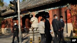 北京当局因一例新冠阳性封闭北京大学。中国警察和保安站在北京大学前监控校门。（2022年11月16日）