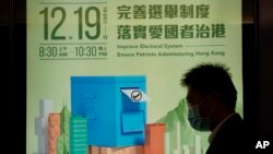 香港一行人走过呼吁港人踊跃投票的宣传广告。（美联社照）