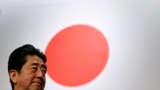 រូបឯកសារ៖ លោក Shinzo Abe អតីតនាយករដ្ឋមន្ត្រីជប៉ុន ឈរនៅមុខទង់ជាតិជប៉ុន ក្រោយពីចូលរួមសមាជបក្សប្រជាធិបេតយ្យសេរីនិយម (LDP) នៅទីក្រុងតូក្យូ ប្រទេសជប៉ុន កាលពីថ្ងៃទី ៥ ខែមីនា ឆ្នាំ ២០១៧។