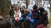 Migrants wait for an appointment with a Belarusian doctor at checkpoint "Kuznitsa" at the Belarus-Poland border near Grodno, Nov. 24, 2021. The EU has accused Belarus' government of orchestrating a migration surge in retaliation for EU sanctions. Belarus denies the assertion.