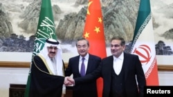 伊朗最高国家安全委员会秘书阿里·沙姆哈尼(右)在北京同沙特国务大臣、内阁成员和国家安全顾问穆萨伊德·本·穆罕默德·艾班握手,中间是中共中央外办主任王毅。(2023年3月10日)
