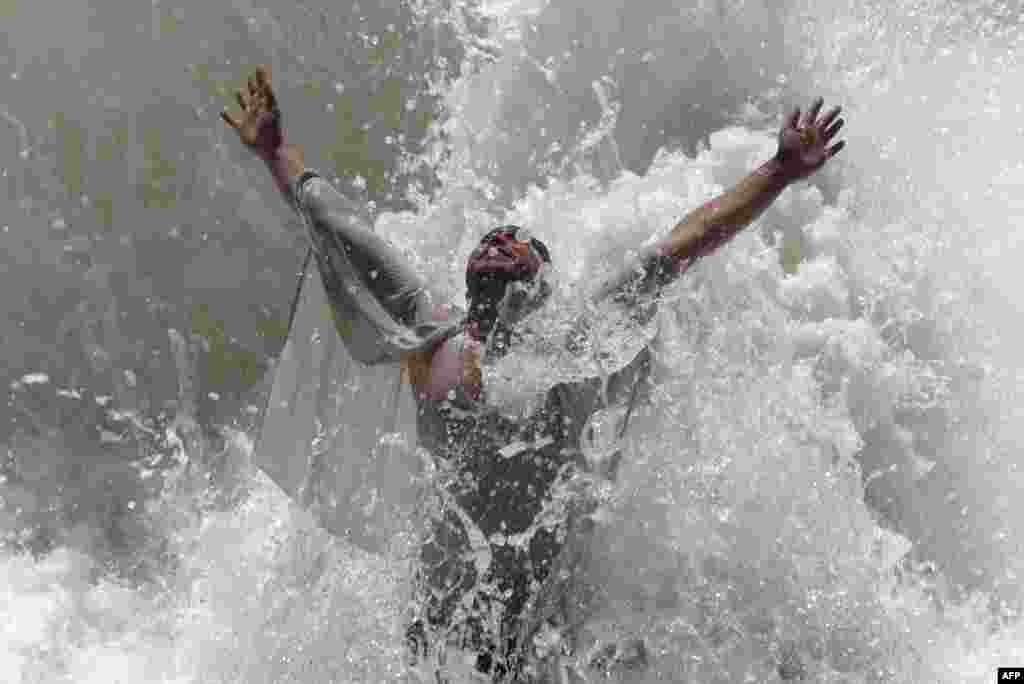 A man cools off on a hot summer day as temperatures reached around 42° C (107.6° F) on the outskirts of Jalalabad, Afghanistan.