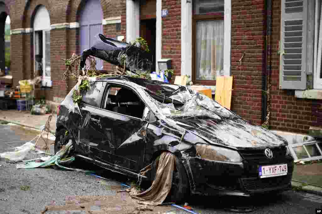 A car is strewn with debris in a residential street after flooding in Ensival, Verviers, Belgium.