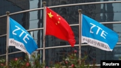 中兴通讯深圳总部外飘扬的该公司旗帜和中国国旗。（2016年4月28日）