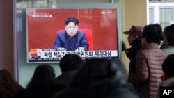 2016年3月3日人们在韩国首尔火车站观看显示朝鲜最高领导人金正恩讲话的电视新闻节目。