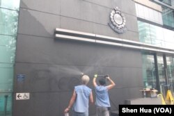 2019年6月27日，工人在高压清洗消除昨晚抗议者喷涂的标语（美国之音申华拍摄）