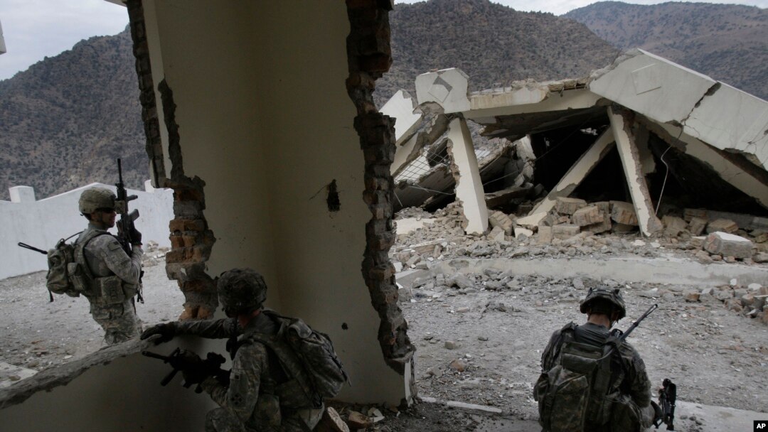 In this Tuesday, Nov. 3, 2009 photo, U.S. soldiers from the 2nd Battalion, 12th Infantry Regiment, 4th Brigade Combat Team, 4th Infantry Division wait inside a destroyed health clinic in the village of Qatar Kala in the Pech Valley of Afghanistan.