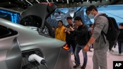 參觀者在北京舉行的2024中國國際車展上觀看中國製造的吉利Galaxy E8電動車車型。 (2024年4月28日)