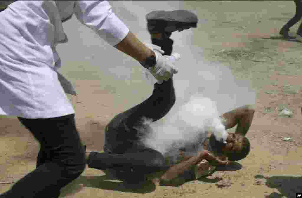 Palestinian medic rushes to a a protester who got shot in his mouth by teargas canister fired by Israeli troops near the Gaza Strip's border with Israel, east of Khan Younis, in the Gaza Strip.