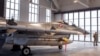 A military police officer stands in front of a Danish Royal Air Force F-16 fighter jet during the welcome ceremony at the Siauliai air force base some 230 km (144 miles) east of the capital Vilnius, Lithuania, Jan. 28, 2022.