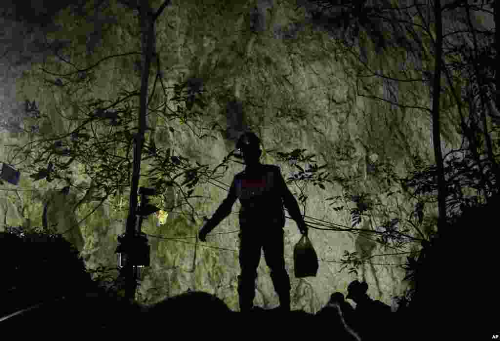 Rescuers make their way down at the entrance to a cave complex where 12 boys and their soccer coach went missing, in Mae Sai, Chiang Rai province, in northern Thailand. The frantic effort to locate them in the cave for a week picked up pace as a break in the rain eased flooding in the system of caverns and more experts from around the world joined the anxious rescue mission.
