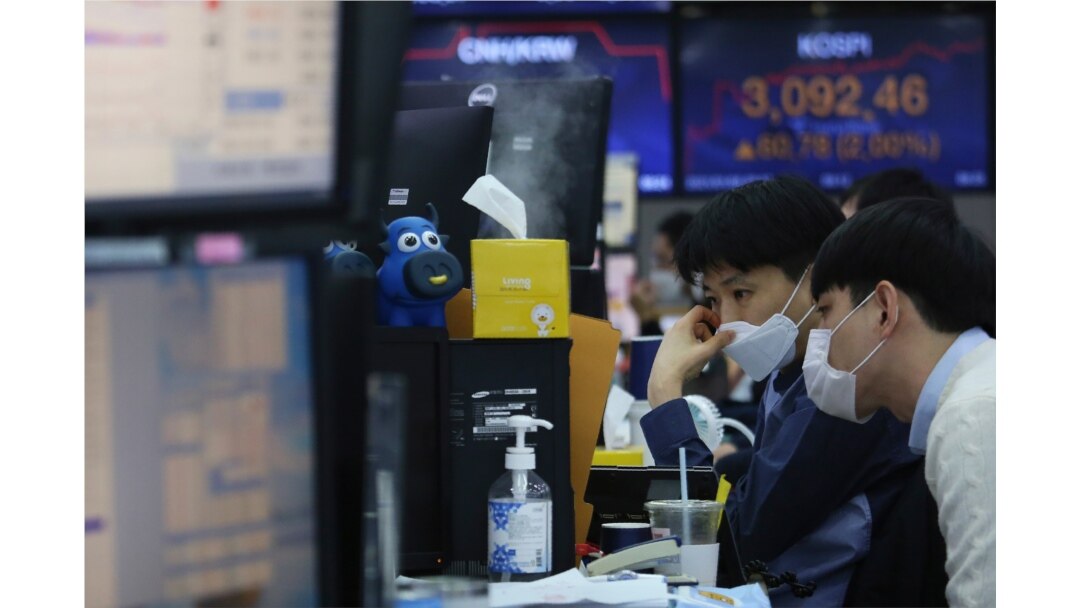 Currency traders watch monitors at the foreign exchange dealing room of the KEB Hana Bank headquarters in Seoul, South Korea, Jan. 8, 2021.