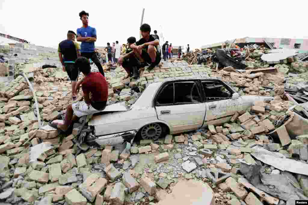 People gather at the site of an explosion in Baghdad's Sadr City district, Iraq.