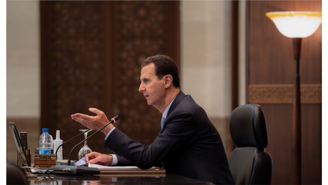 Syria's President Bashar al-Assad speaks as he meets with the Syrian cabinet in Damascus, Syria, in this handout picture released by Sana on March 30, 2021.