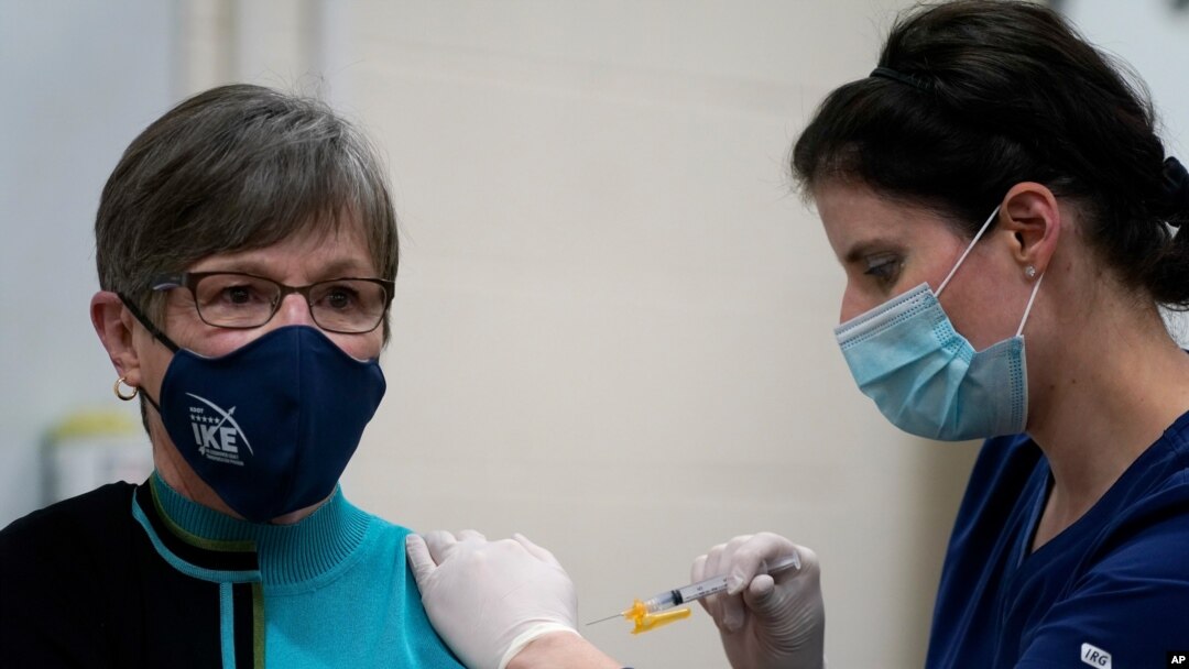 Public health nurse Lisa Horn gives a COVID-19 vaccine injection to Kansas Democratic Gov. Laura Kelly Wednesday, Dec. 30, 2020, in Topeka, Kansas.