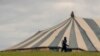 FILE - A man carrying a bag walks past a large unoccupied church marquee after Easter Weekend celebrations were cancelled due to lockdown to prevent the spread of coronavirus, at Katlehong near Johannesburg, South Africa, April 10, 2020, 