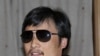 In this photo released by the US Embassy Beijing Press Office, blind lawyer Chen Guangcheng makes a phone call as he is accompanied by U.S. Ambassador to China Gary Locke in a car on the way to a hospital in Beijing, May 2, 2012.