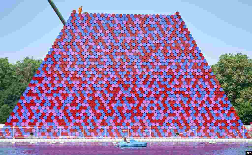 Workers build 'The Mastaba', an outdoor work made up of over 7000 stacked barrels by Bulgarian artist Christo Vladimirov Javachef on the Serpentine lake in Hyde Park in London.