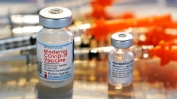 FILE - Vials for the Moderna and Pfizer COVID-19 vaccines are displayed on a tray at a clinic set up by the New Hampshire National Guard in the parking lot of Exeter, N.H., High School, Feb. 25, 2021.