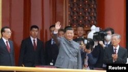 2021 年 7 月 1 日，在北京天安门广场举行的中国共产党成立 100 周年纪念活动结束时，中国国家主席习近平在李克强总理和前国家主席胡锦涛旁边挥手致意。