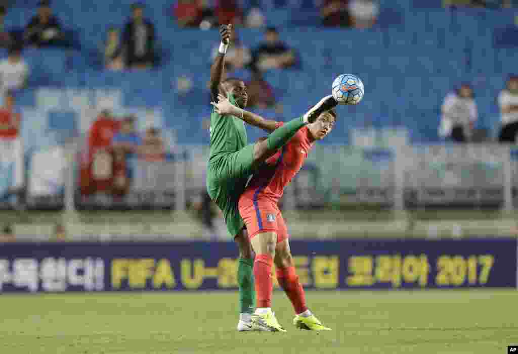 Nigeria's Erimuya Saturday Keigo (l) struggles for the ball against South Korea's Hwang Hee-chan during the 4 Nations International U-23 Football Tournament 2016 at the World Cup Stadium in Suwon, South Korea.