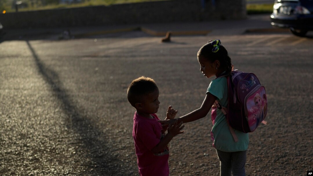 The children of Venezuelan migrants Miguel Gonzalez and Maryelis Rodriguez wait for a transportation that will take their family of six to the border with Brazil, in Santa Elena, Venezuela, April 5, 2023.