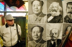 一路人观看在北京一市场里悬挂的共产主义领袖像。