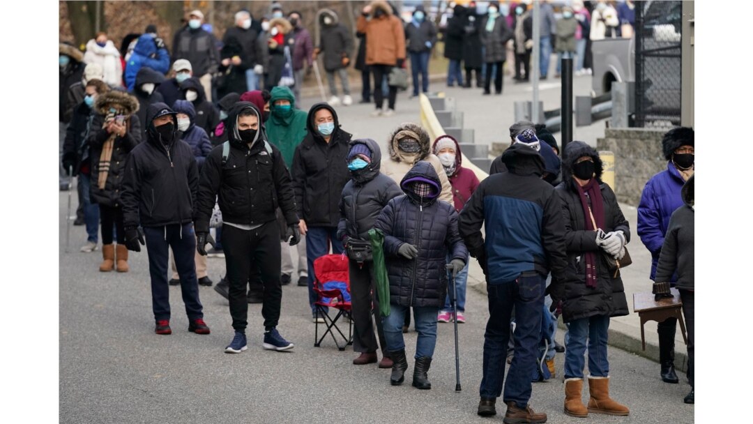 People wait in line at a COVID-19 vaccination site in Paterson, New Jersey, Jan. 21, 2021.
