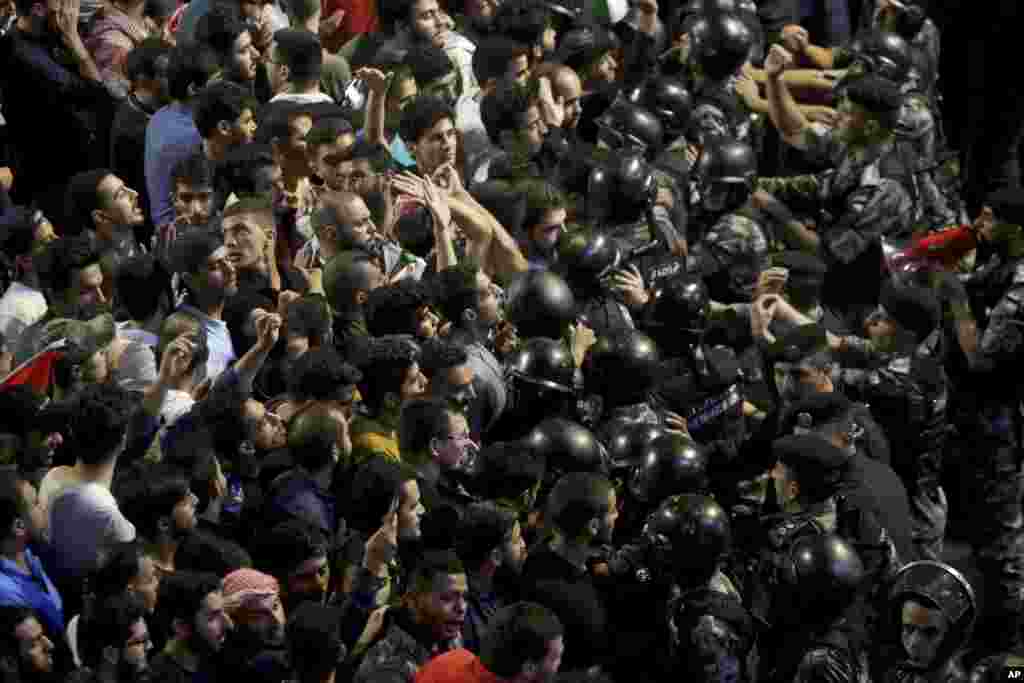 Jordanian riot police and security forces scuffle with protesters during a demonstration outside the Prime Minister's office in Amman.
