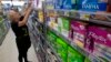 FILE - Tammy Compton restocks tampons at Compton's Market, in Sacramento, Calif., June 22, 2016. Bills to exempt feminine hygiene products and diapers from sales taxes were vetoed by Gov. Jerry Brown in 2016, but the measure's author's are reintroducing the proposals.