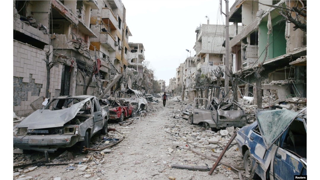 FILE - Damaged cars and buildings are seen in eastern Ghouta, Damascus, Syria, Feb. 25, 2018.