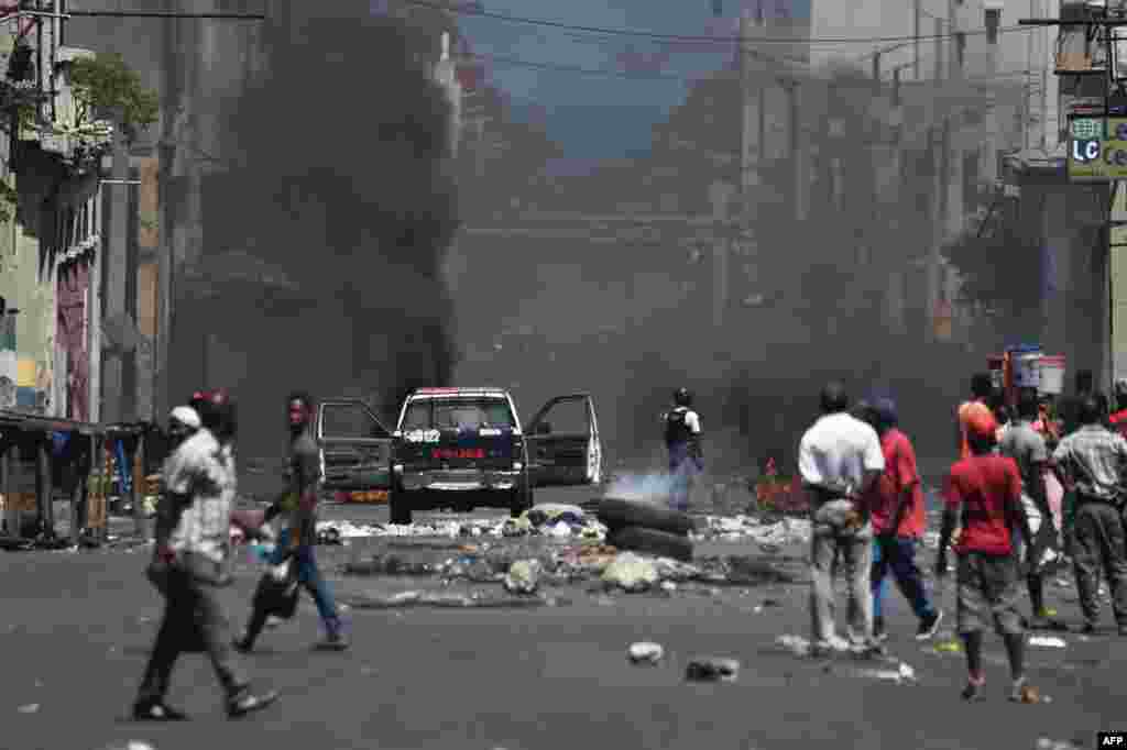 Police stand guard on a street in central Port-au-Prince, Haiti, following two days of deadly looting and arson triggered by a quickly-aborted government attempt to raise fuel prices.
