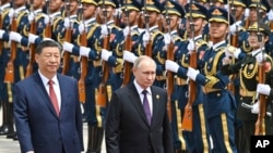 资料照片：2024年5月16日，中国国家主席习近平(左)和俄罗斯总统弗拉基米尔·普京在中国北京举行的官方欢迎仪式上检阅仪仗队。