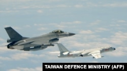 这幅2018年5月11日由台湾军方发布的照片显示，台湾空军一架F-16战斗机与一架军演中的中国空军H-6轰炸机并行。