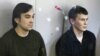 Yevgeny Yerofeyev (L) and Aleksander Aleksandrov, Russian servicemen arrested last May on terrorism charges related to the separatist conflict in eastern Ukraine, looks from a glass-walled cage during a court hearing in Kyiv, Ukraine, April 18, 2016.