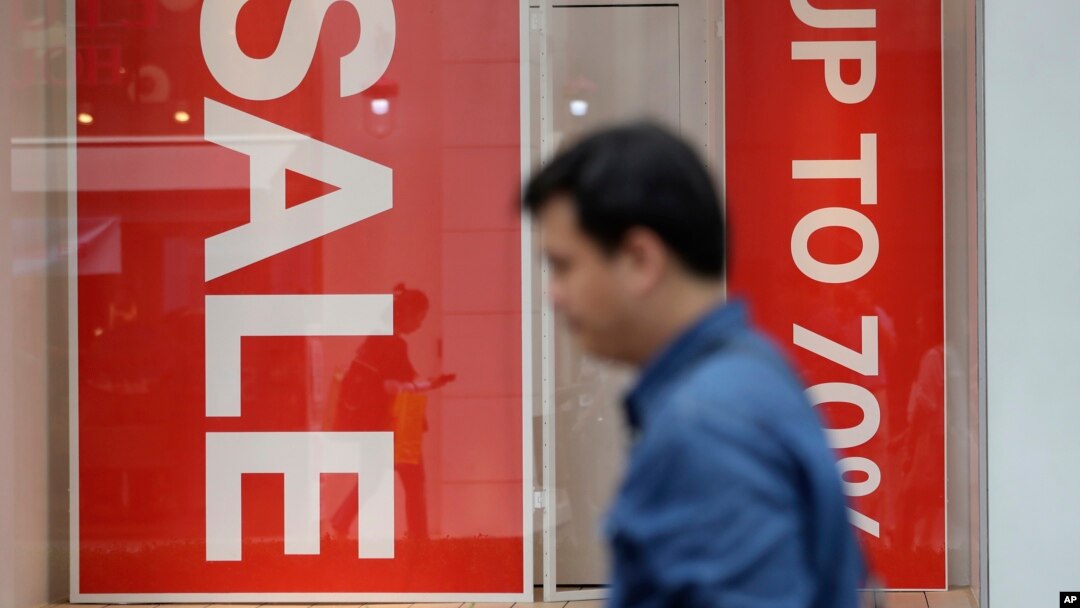 A man passes by sale signs at a shopping district in Seoul, South Korea, July 13, 2017. Bank of Korea says South Korea's economy is likely to expand 2.8 percent this year thanks to strong exports.