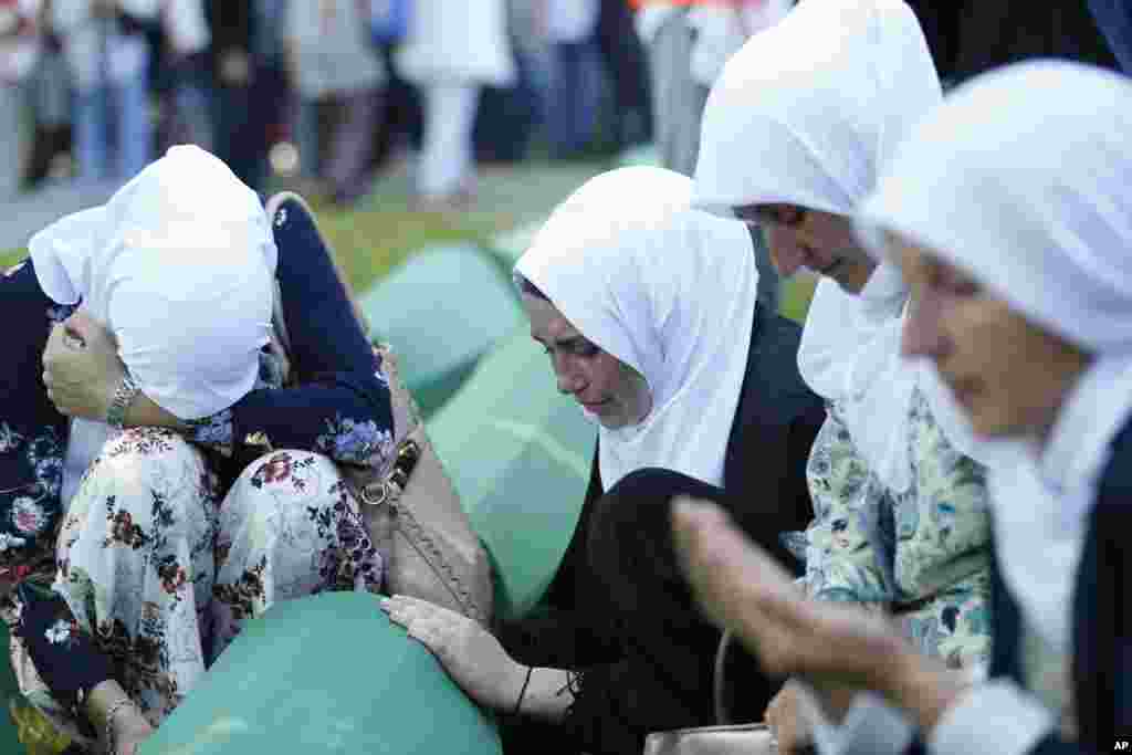 Bosnian Muslim women react near the coffin of one of the 35 identified victims of the 1995 massacre, at the memorial center of Potocari near Srebrenica, 150 kms north east of Sarajevo. Thousands of Bosnian Muslims have gathered in Srebrenica on the 23rd anniversary of Europe's worst massacre since World War II to hold prayers and attend the funeral for 35 recently identified victims.