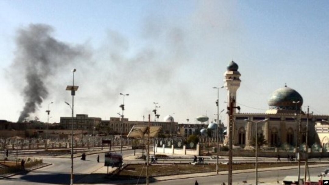 A plum of smoke is seen following a wave of attacks prior to the storming a police compound in the western Iraqi city of Ramadi, January 15, 2012.