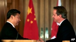 中国国家主席习近平（左）和英国首相卡梅伦2015年10月21日在伦敦唐宁街举行联合记者会。