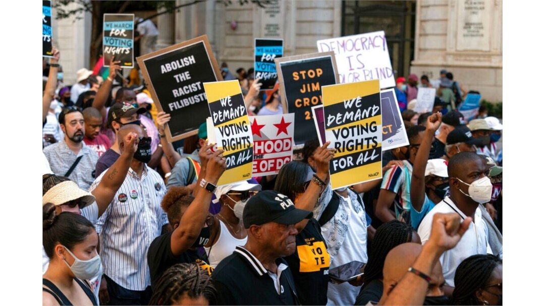 Demonstrators hold signs during a march for voting rights, marking the 58th anniversary of the March on Washington, Aug. 28, 2021, in Washington.