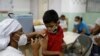 Luis Duarte, de 5 años, recibe una dosis de la vacuna Sinopharm contra la enfermedad del coronavirus (COVID-19) para asegurar la protección contra la variante del coronavirus ómicron, en Caracas, Venezuela, el 9 de diciembre de 2021.